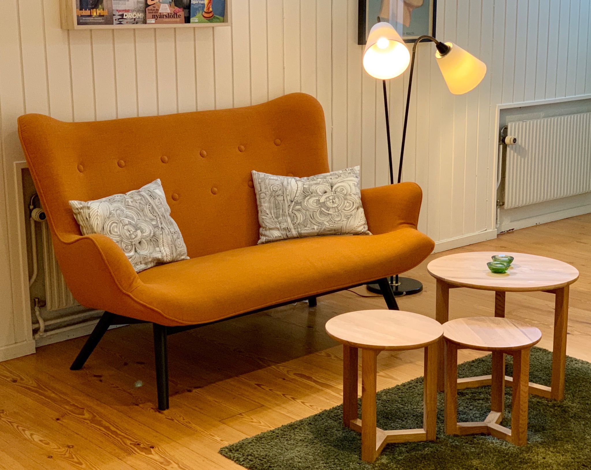 Sittgrupp hos Alstra Psykologbyrå med ockragul soffa, ljusa träbord och varm belysning.